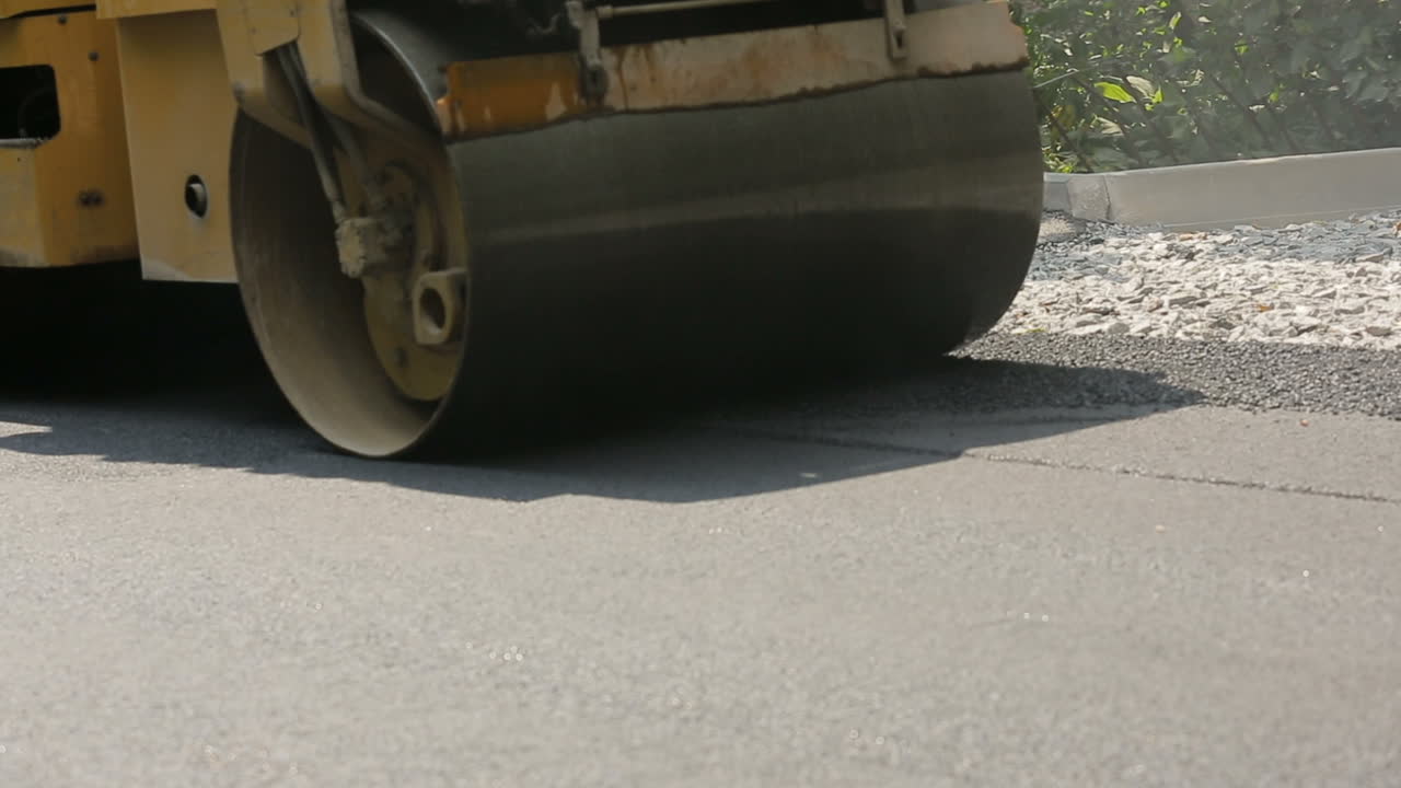 Road rollers leveling fresh asphalt pavement