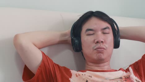 무선 헤드폰을 통해 음악을 듣는 아시아인
