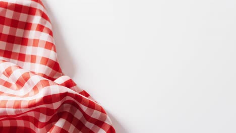 Close-up-of-red-and-white-checkered-blanket-on-white-background-with-copy-space