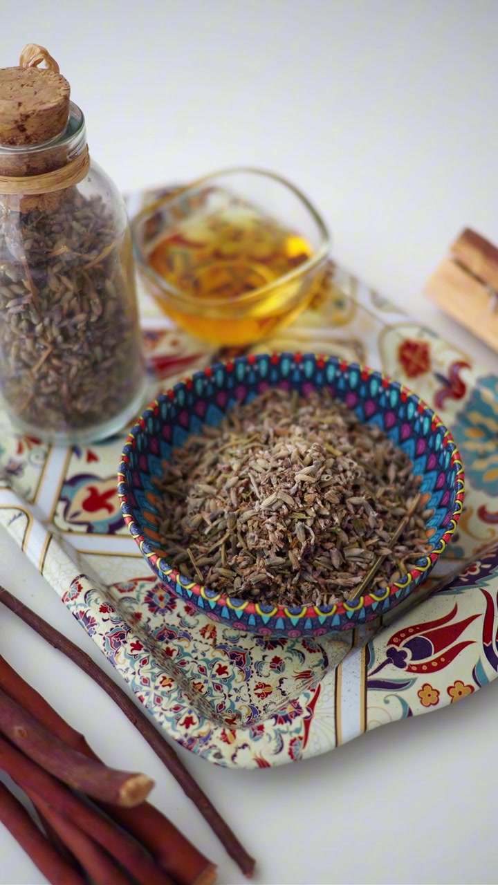 Aromatherapie benodigdheden met gedroogde kruiden, olie en Palo Santo op een dienblad