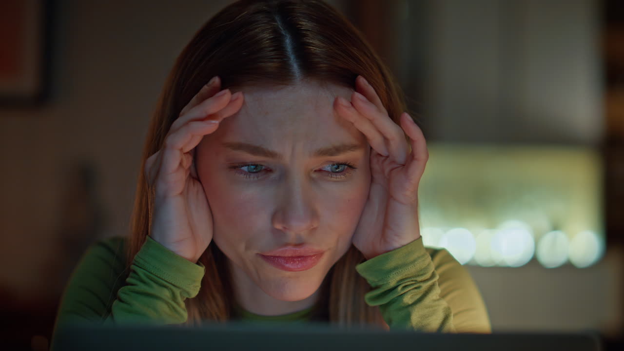 Remote employee worried deadline looking laptop screen in dark apartment closeup