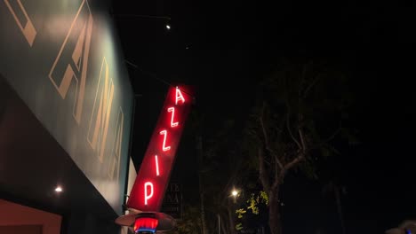 Illuminated-neon-pizza-restaurant-glowing-signage-advertisement-on-building-exterior-at-night