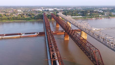 Aerial-of-river-barge-under-three-steel-bridges-over-the-Mississippi-River-with-Memphis-Tennessee-background-1