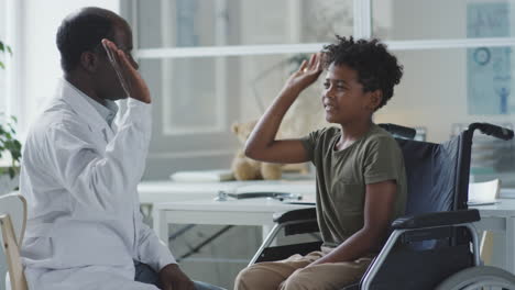 a doctor interacts with a child in a wheelchair