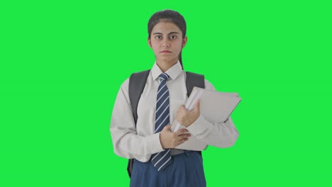 Confident-Indian-school-girl-standing-with-books-Green-screen