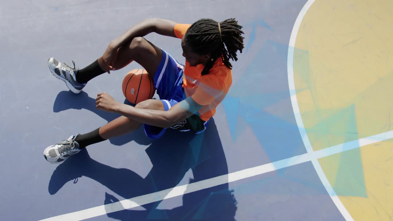 Tired sports player lowering hand, adjusting basketball to rest as blue overlay showing over player