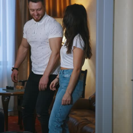 couple with travel bags. woman and man put their suitcases and sit on a sofa after the journey. young couple arrives into the hotel. view from the door