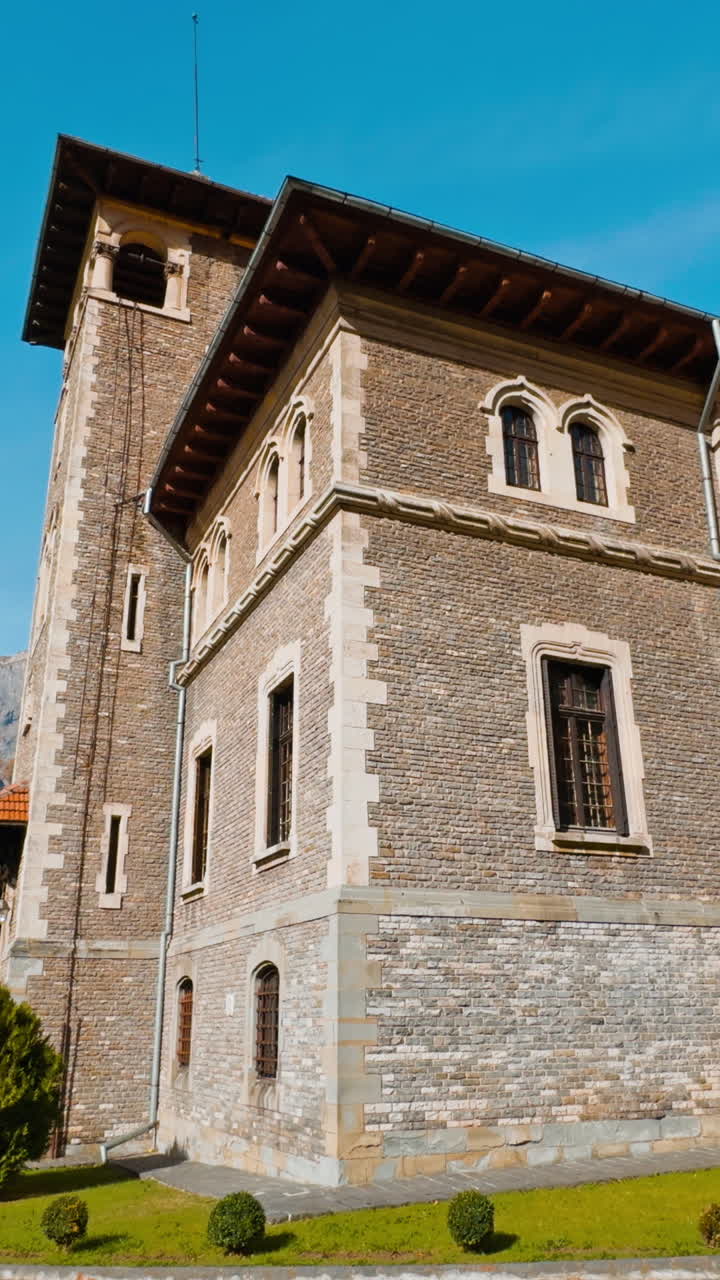 Fasade of the old brick palace at backdrop of mountains. Scenery of cozy autumn near the castle. Vertical video