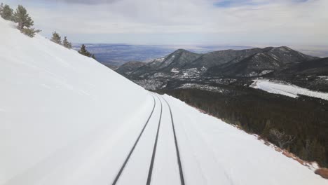 pov from train on snowy cog railway traveling to pikes peak in colorado, usa.