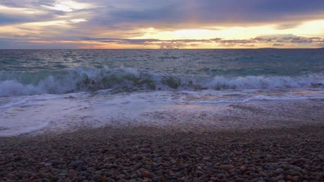 ocean waves with a sunset scenic view of the horizon over a pebbled beach in looc bay, philippines