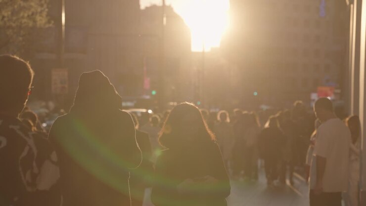 People walking in city street during sunset