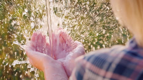 un chorro de agua clara cae en la palma de tu mano video en cámara lenta
