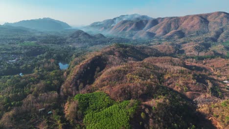 a magnificent mountain range graces the rural landscape of sangklaburi, thailand, offering a picturesque view of nature's grandeur