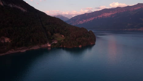 Flying-over-the-shore-of-a-mountain-lake-in-Switzerland-during-golden-hour