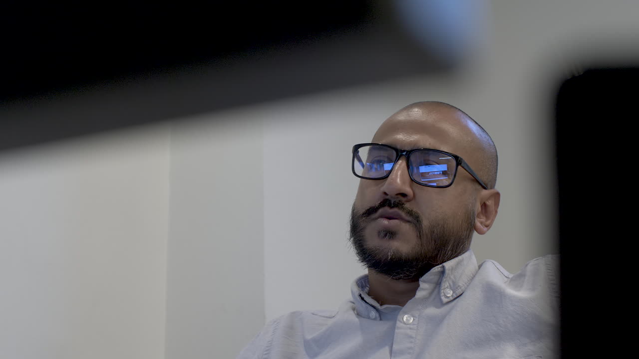 Low angle shot of an Asian man with a beard and glasses