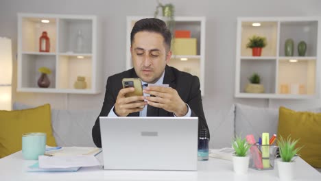 home office worker man shopping on the phone.