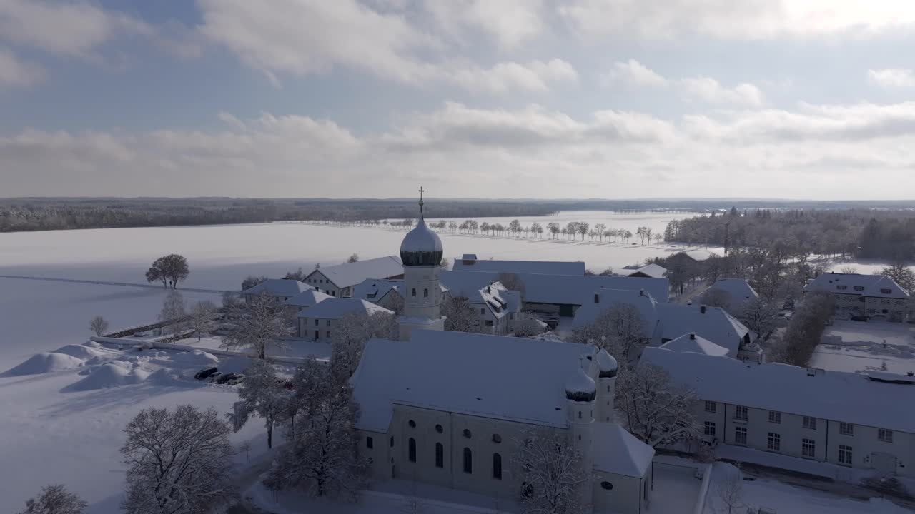 Europa, Tyskland, Bayern - Vinterlandsby med sne og en kirke, luftfoto fra drone, filmisk 4K 60fps
