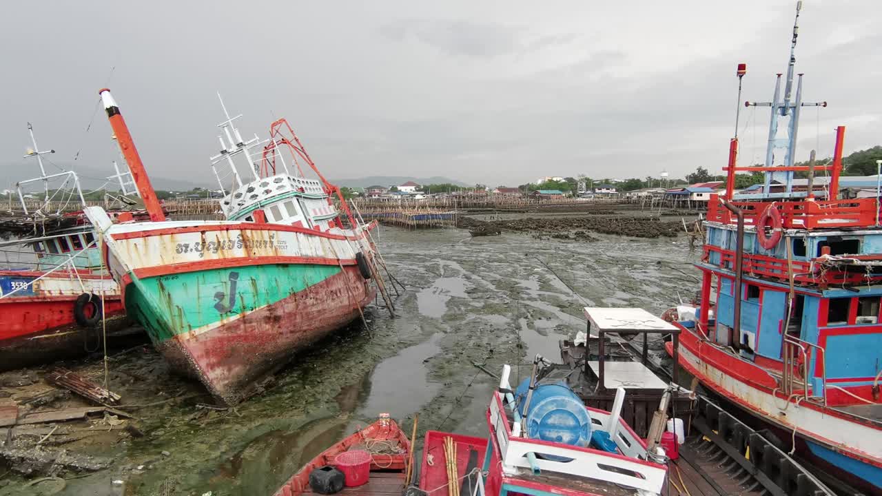 Thai Fishing Trawlers Grounded on Low Tide in the Harbor near Chonburi, Thailand
