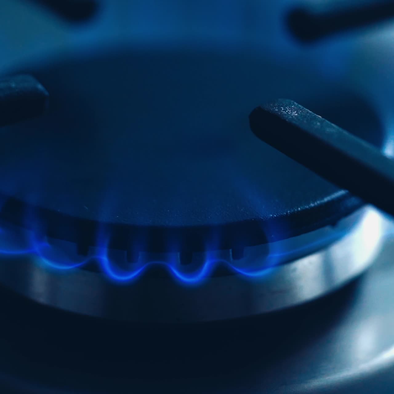 Natural gas kitchen cooker turn on and recently used. Blue and really hot flames on a gas stove. Homemade cooking concept. Circle gas hob burning ready to be use. Natural gas inflammation, close up.