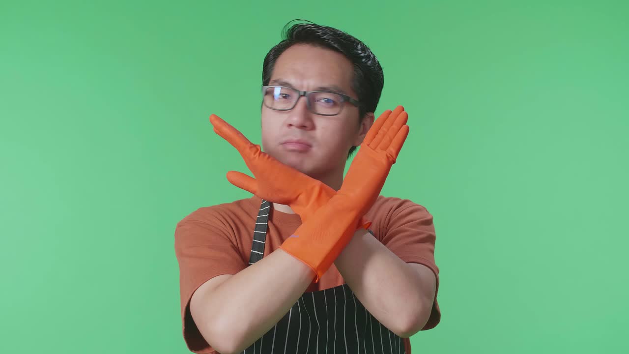 녹색 스크린 스튜디오에 서 있는 동안 금지 조치를 보여주는 전면으로 동의하지 않는 아시아 남성 집주인