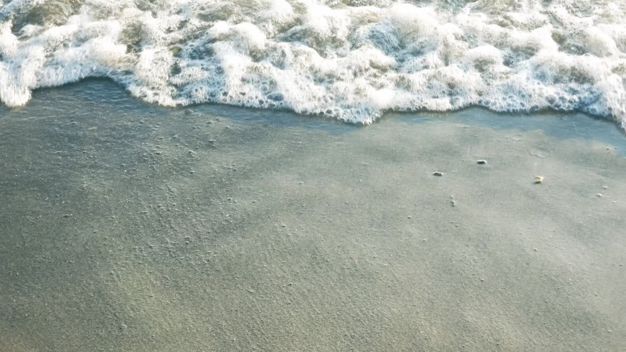 황금 시간에 해변에 접근하는 파도 닫습니다