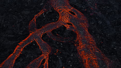 Streams-of-red-hot-lava-flowing-during-a-volcano-eruption,-aerial-shot