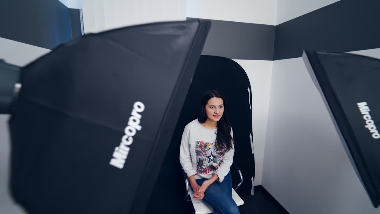 Young female model at studio. Interior and the equipment of a photographer during photo session