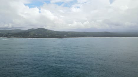 Scenic-View-Of-A-Tranquil-Beach-With-Mountains-And-Blue-Sky-With-Clouds-In-Sapphire-Beach,-Coffs-Harbour,-NSW,-Australia---aerial-drone-shot