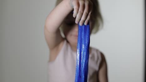 child having fun making slime. kid playing with hand made toy slime.