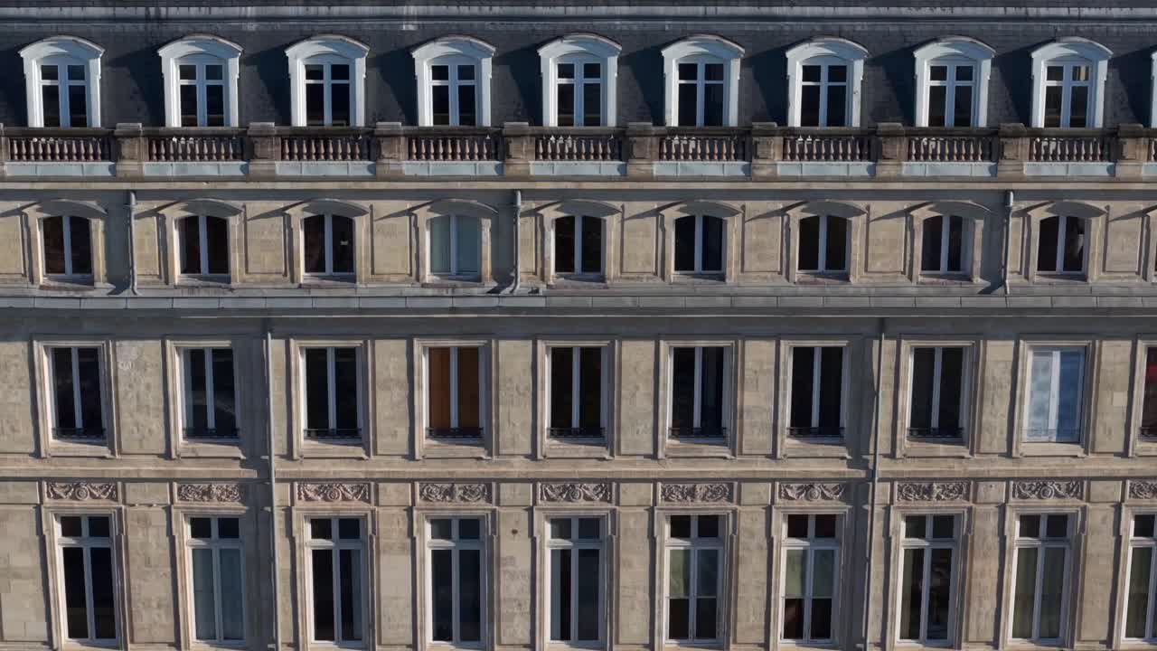A stunning view shows a historic building with intricate architecture. The camera captures multiple angles, highlighting its windows and decorative design in Bordeaux City