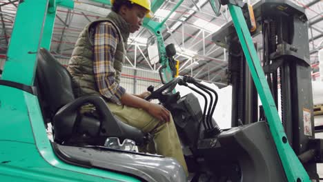 Female-worker-driving-forklift-in-a-warehouse