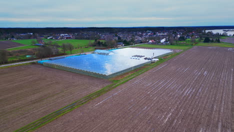 agriculture field with greenhouse next to meeuse river dutch landscape aerial