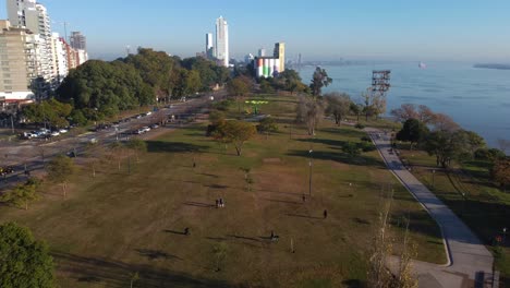 people with your pets enjoy the sunny morning at the park with buildings the river and the bridge at the background