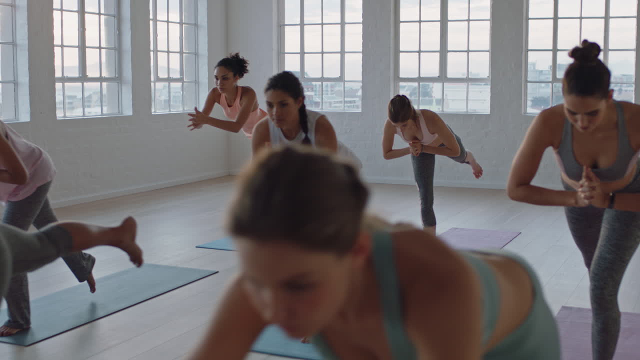 clase de yoga de mujeres sanas practicando pose guerrera disfrutando del ejercicio en el gimnasio instructor líder grupo meditación enseñando postura de entrenamiento al amanecer