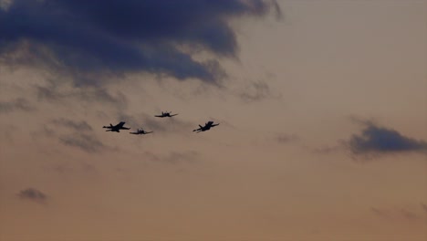 fighter jets fly in formation during sunset