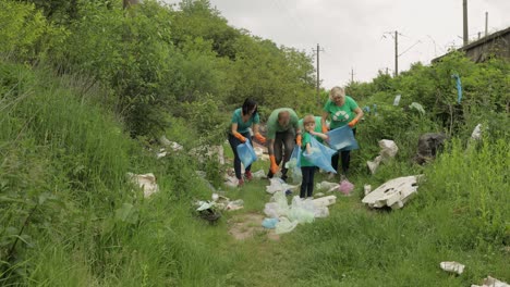 Volunteer-team-cleaning-up-dirty-park-from-plastic-bags,-bottles.-Reduce-trash-cellophane-pollution