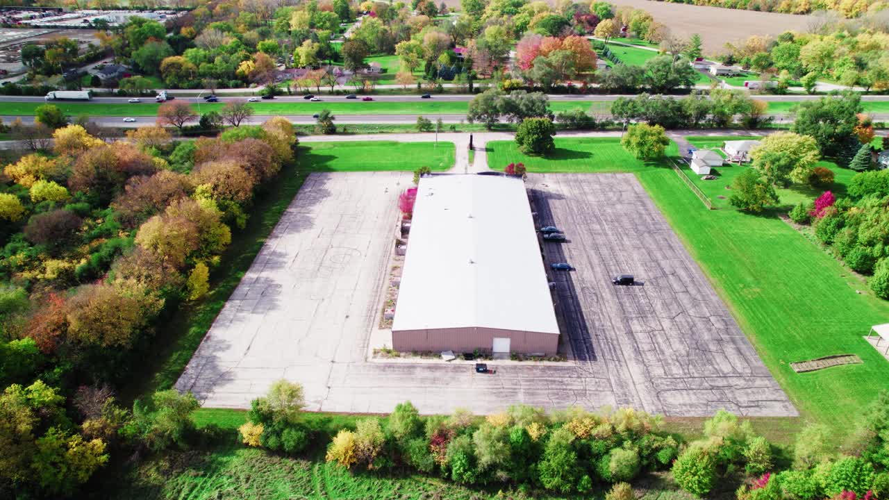 큰 창고 의 쪽 에어리얼 과 화려 한 가을 잎자루 사이 의 공허 한 부지