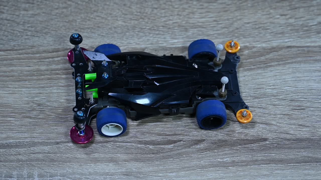 태국 방 ⁇  의 한 상점 의 테이블 위 에 놓인 타미야 미니 스포츠 자동차 를 확대 하고 있다