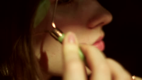 mujer usando un rodillo de jade para masaje facial