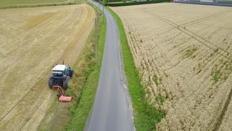 drone shot of a tractor mowing the grass verge