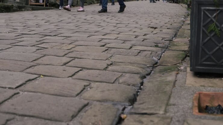 Shoppers browsing in cobbled street in Yorkshire village Haworth low shot