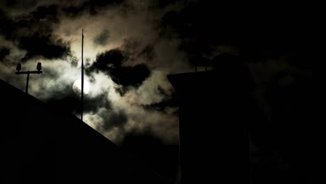 4k uhd 3840x2160: full moon with clouds time lapse with old town roofs silhouettes