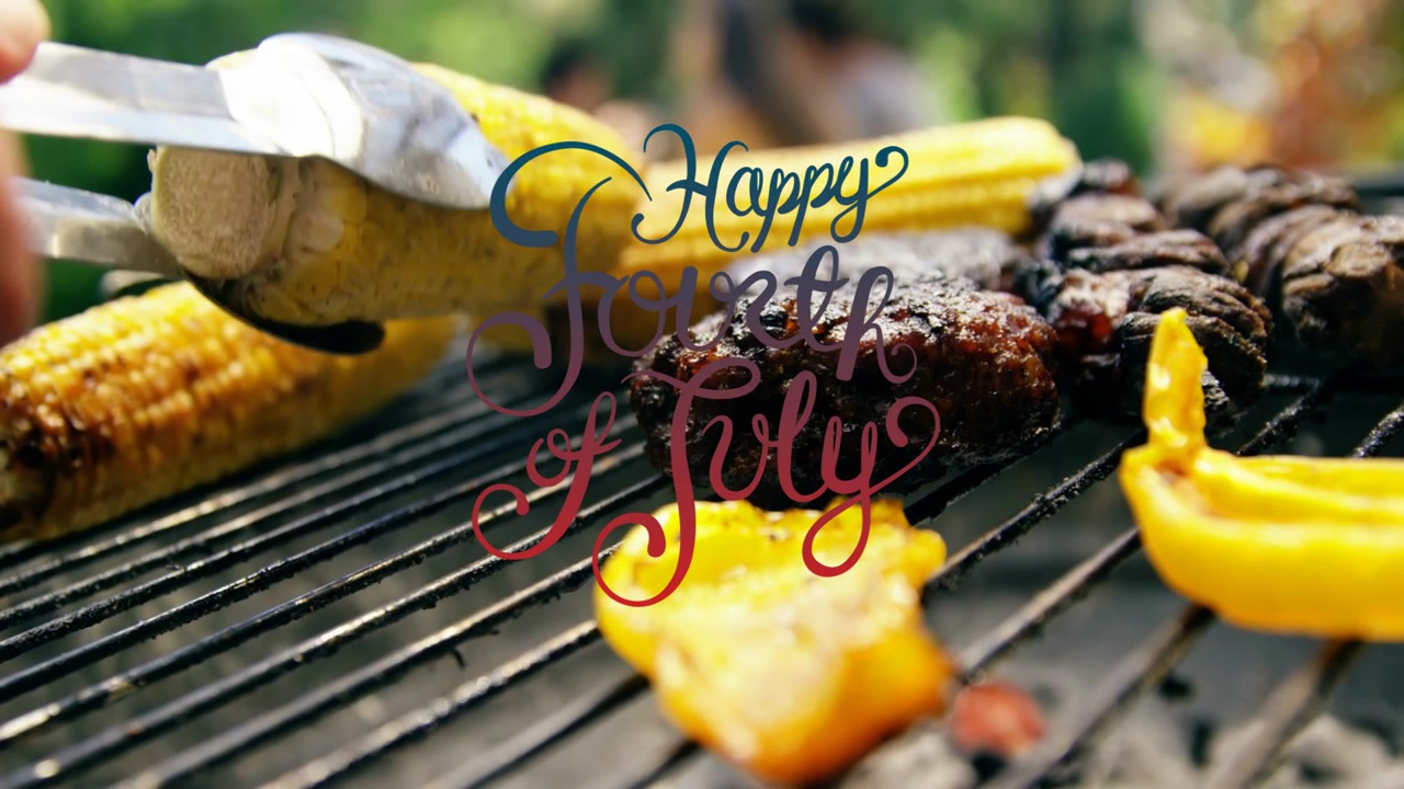 Tang nærmer sig majs, en hånd vender, presser og tilbereder jævnt til en grillfest den fjerde juli.