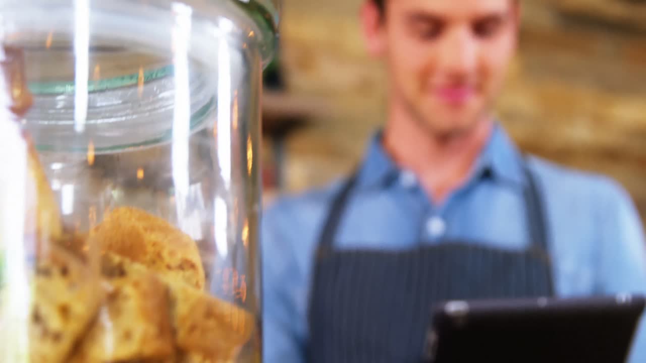 camarero masculino usando una tableta digital en el mostrador