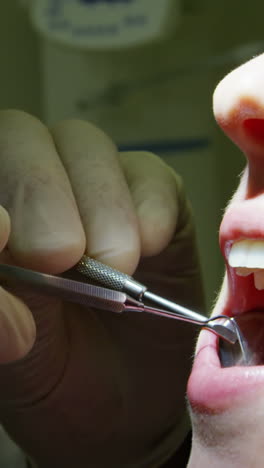 dentist examining a female patient with tools