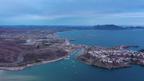 aerial-shot-from-drone-over-the-sea-towards-a-marina-with-a-sunny-day-at-high-altitude-and-view-of-the-ocean