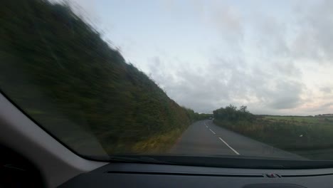 Zeitraffer-Auto-POV-Auf-Landstraße-Bei-Sonnenuntergang-Mit-Vorbeifahrenden-Autos-Und-Kreuzungen-In-Devon,-Großbritannien-4k