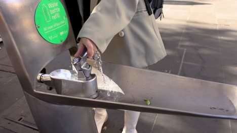 person using a public water fountain