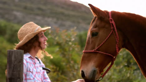 una mujer bonita alimentando a un caballo.