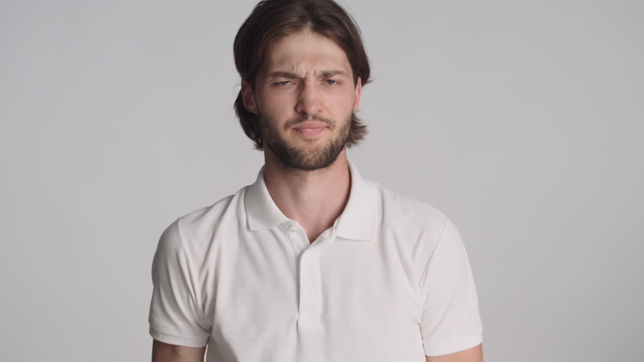 회색 배경에서 카메라 앞에 있는 백인 남자.